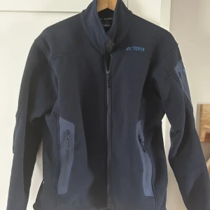 Arc’teryx fleece - Snygg mörkblå Arc’teryx fleece i nyskick Säljer då den är för liten, försiktigt använd. Storlek S passar S-Liten M