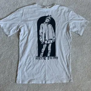 Krämvit Billie Eillish t-shirt med tryck från H&M Ca 63 cm lång och strl 146/152