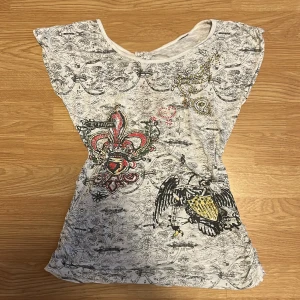 Topp - Topp med tryck och strass och liten öppning i ryggen. Storleken är tyvärr bortklippt med passar storlekarna S-M bäst. Liknar ed Hardy tröjorna. Fint skick💗 