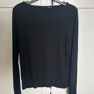 Svart ribbad långarmad tröja.  - Den är ribbad med öppna ärmar. Har använts få gånger. 💕Säljer den för att den är för stor 