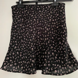 Svartblommig minikjol - Svart minikjol med rosa rosor på, storlek 34/xs från H&M