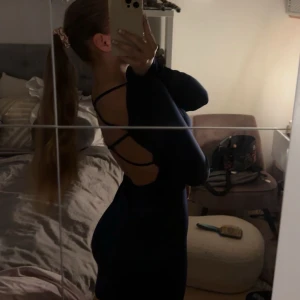 Marinblå klänning - Superfin marinblå klänning med korsande band i ryggen! Säljer för att jag beställde fel, men den är helt ny och passar perfekt!