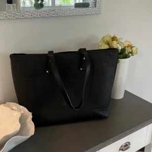 Svart väska  - Jag säljer en jättefin svart väska❣️ Väskan är rymlig och i relativt bra sick förutom lite små märken som tyvärr syns🤩
