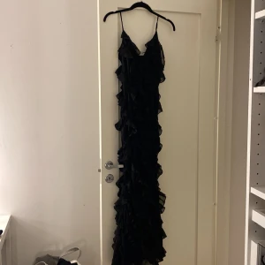 Balklänning - Helt ny jättefin balklänning. Aldrig använt, storlek 36, svart med volanger och v ringning, skriv privat för bild på! 