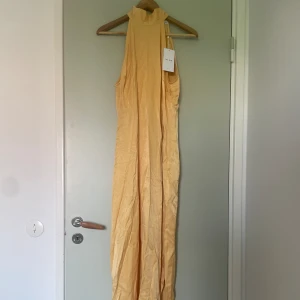 balklänning  - jättefin gul balklänning från Vila!! Aldrig använd med lappen kvar. Jättegullig halterneck som man knyter i nacken. Slit på ena sidan och en dragkedja. I storlek 38, är lång på mig som är 162 så passar perfekt om man är lite längre💖