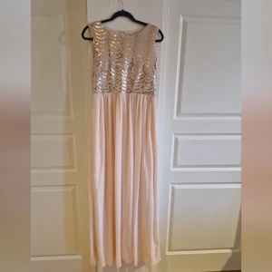 Klänning  - Fin aftonklänning som enbart använts 1 gång. Rosa/persikofärgad med fina paljetter i rosé. 