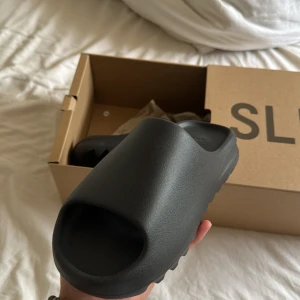 Yeezy slide onyx  - Helt nya Yeezy Slide prefekt inför sommaren. Kvitto finns från CONFIRMED appen. Skulle säga att de passar stl 41 och fraktar med dubbel box självklart, hör av er vid frågor 🍀