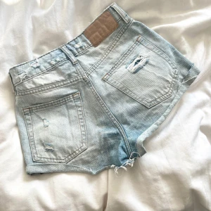 Jeansshorts  - Jättefina jeansshorts med slitningar i en ljusblåa färg. Sitter som en Xs