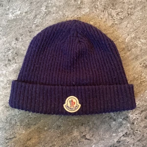 Moncler mössa  - Mörk blå mössa, tagen i mössa är lite sönder annars perfekt,pris kan diskuteras vid snabbt köp 