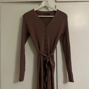 Stickad klänning - Säljer brun stickad klänning (köpt på Plick) då den inte passar mig riktigt. Otroligt mjuk och skön! Stretchigt material. Storlek M men skulle säga att den är lite liten i storlek så snarare S/M. Slutar precis ovanför knäna på mig som är 165 ✨