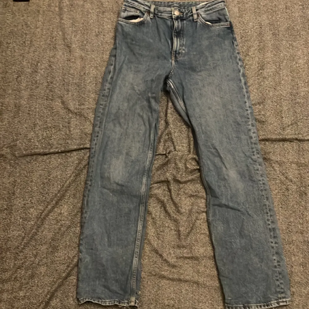 Ljusblåa jeans från Monki i storlek 26, ja är 160cm och ja tror att de skulle passa från typ 150-165cm. De är lite baggy och högmidjade. Använda och är lite slitna längst ner på båda benen.. Jeans & Byxor.