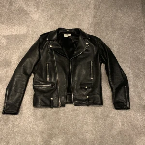 Saint Laurent leather jacket - Säljer en saint Laurent läder jacka. Jackan är äkta och det är äkta lammskinn. Storlek 48/m. Nypris 45 000 kr mitt pris 20 000 kr. 