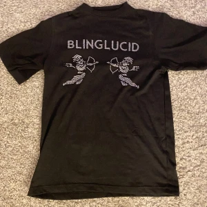 Bling lucid  - Säljer en helt ny bling lucid t-shirt i storlek xs fick den k julklapp men den var för liten så den är bara testad en gång ! Det är två änglar som skjuter med pil båge i rhinestone 
