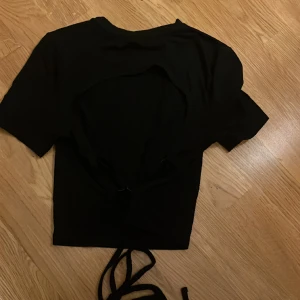 Svart t-shirt med öppen rygg  - Svart t-shirt, skönt material och använd 1 gång. 