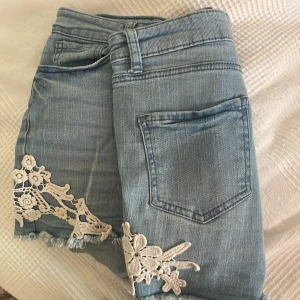 Jeans shorts - Säljer de här fina jeansshortsen med fina blommiga detaljerna. Säljer pga att jag inte använder de. Storlek 36, säljer för 100kr.