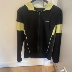 Hugo boss zip - Väldigt fin zip tröja från boss. Den har lite anmärkningar som man kan se på bilden men annars väldigt fint skick. Tröjan hör till ett sett men jag säljer bara tröjan.  Tveka inte att skriva till mig om ni har frågor.  