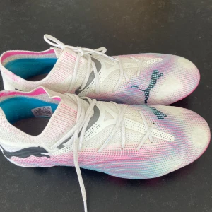 Puma fotbollskor  - Säljer dessa PUMA Future 7 Ultimate FG/AG Phenomenal - Vit/Svart/Poison Pink. Använt 1 gång men säljer psg av förstora, skorna är i storlek 40. Är som sagt nästa helt nya. Pris kan diskuteras💘💘💘💘