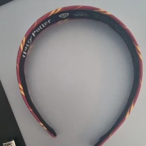 Diadem  - Säljer detta diadem med gryffindormönster då jag inte använder det längre. Sitter ganska tajt på mitt huvud. Meddela ifall du är intresserad av att köpa. Säljer även matchande scrunchie. Går att diskutera pris. Meddela vid frågor eller intresse 