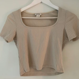 Ribbad Croptop i beige - Ribbad, kortärmad croptop från Monki! Den passar till allt och är toppen att ha under tröjor eller till jeans! Väldigt bra skick😊 Skriv för fler bilder💗🌟