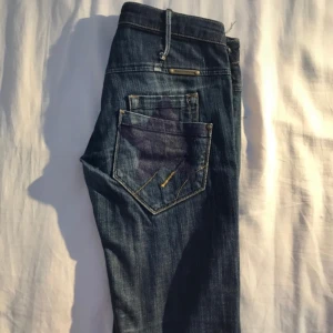Bootcut fornarina jeans - Bootcut vintage jeans från 2000 talet med stjärnor på bakfickorna. Har två små revor på framsidan, syns på bilderna. Köpte av en tjej men passade tyvärr inte så säljer vidare! Använda tidigare men i bra skick fortfarande. ❣️