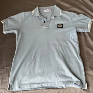 Stone island piké 12år/156cm - Säljer en gråblå Stone Island piké i storlek 12 år / 156 cm. Fint skick, använd få gånger. Nypris 1200 kr.  Pris: 650 kr  Kontakta mig för mer information. Endast  avhämtning.