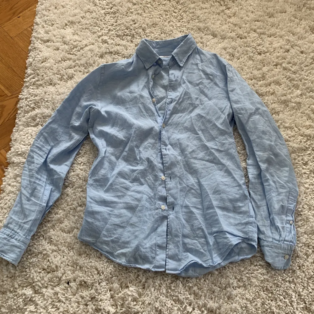 Blå linneskjorta från uniqlo i storlek xs men mer av en s. Bra skick och sparsamt använd.. Skjortor.