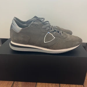 Philippe Model Trainers - Säljer ett par mörkgröna Philippe Model Trainers i storlek 42. Skorna är i bra skick och är riktigt användbara då de passar till alla outfits. Kan skicka eller mötas upp i Stockholm innerstad.