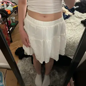 En vit kort kjol från shein som har ett innerlager med tyg, köpt på second hand men aldrig använd 