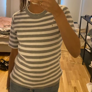 Grå randig tröja  - Fin trekvarts tröja, jätteskönt och bra material. Använd ett fåtal gånger (1/2 ggr). XS men passar även S. Köpt för ca 400 kr💞