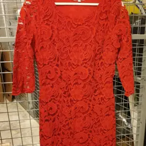 Röd spetsklänning som är knälång med 3 kvartsärm i nyskick. Strl 38. Katt finns I hemmet