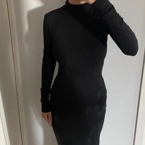 Klänning - Väldigt fin klänning med snygg detalj på ryggen. Klänningen har en krage som man kan vika ner. 