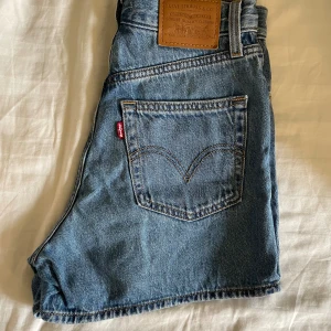 Levis shorts - Högmidjade kort jeansshorts från Levis. Köpta i Cypern 2022 för 700kr och väl använda under den sommaren (men i mycket bra skick). Säljes då de är för små.