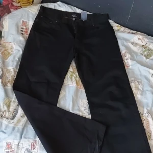 Tunna jeans - Tunna jeans aktiga byxor från L.o.g.g från H&M med knappar i storlek 34/34.  Lite använda, liten synbar skiftning av färg längst ner på benet pga användning. Men inget märkbart i det stora hela se bild 3