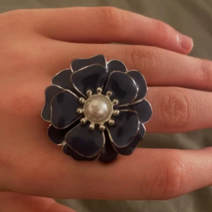 Blommring - Blom ring i en jättefin blå färg med en pärla i mitten! Rostfri, den är använd och säljer för att den är för stor. Skick 8/10❣️