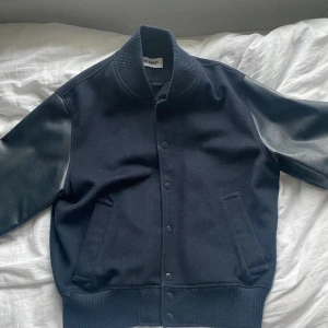 Weekday varsity jacka - En varsity jacka från weekday i storlek M. Ei en väldigt mörkblå färg och med en passform som är lite boxig. Varsamt använd och i gott skick:)