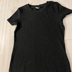 Svart t-shirt - Säljer denna fina och oanvända t-shirten som är väldigt stor i storleken och passar folk som använder storleken XS. En vanlig svart t-shirt som passar till allt🤩