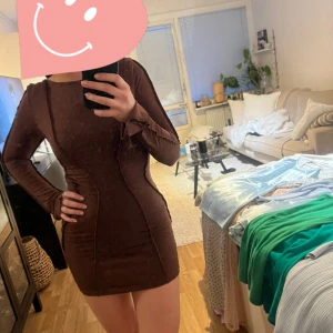 Klänning öppen rygg - Snygg brun klänning som formar kroppen. Snörning i ryggen för tight passform. Använd en gång. Storlek xs från Nelly 