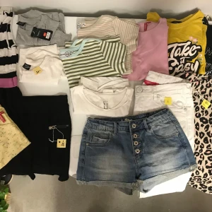 Klädpaket 146-152 -  15 plagg alla i storleken 146-152. Två byxor/tights, ett par halvlånga vita byxor, ett par jeans shorts, en klänning, en kjol, tre linnen, 6 tröjor. Allt väger 2kg. 