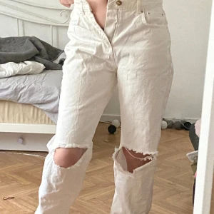 Vita jeans med hål  - Högmidjade, hålet i ena knät har blivit lite större. Har inte använt alls mycket, lite tajt i midjan 