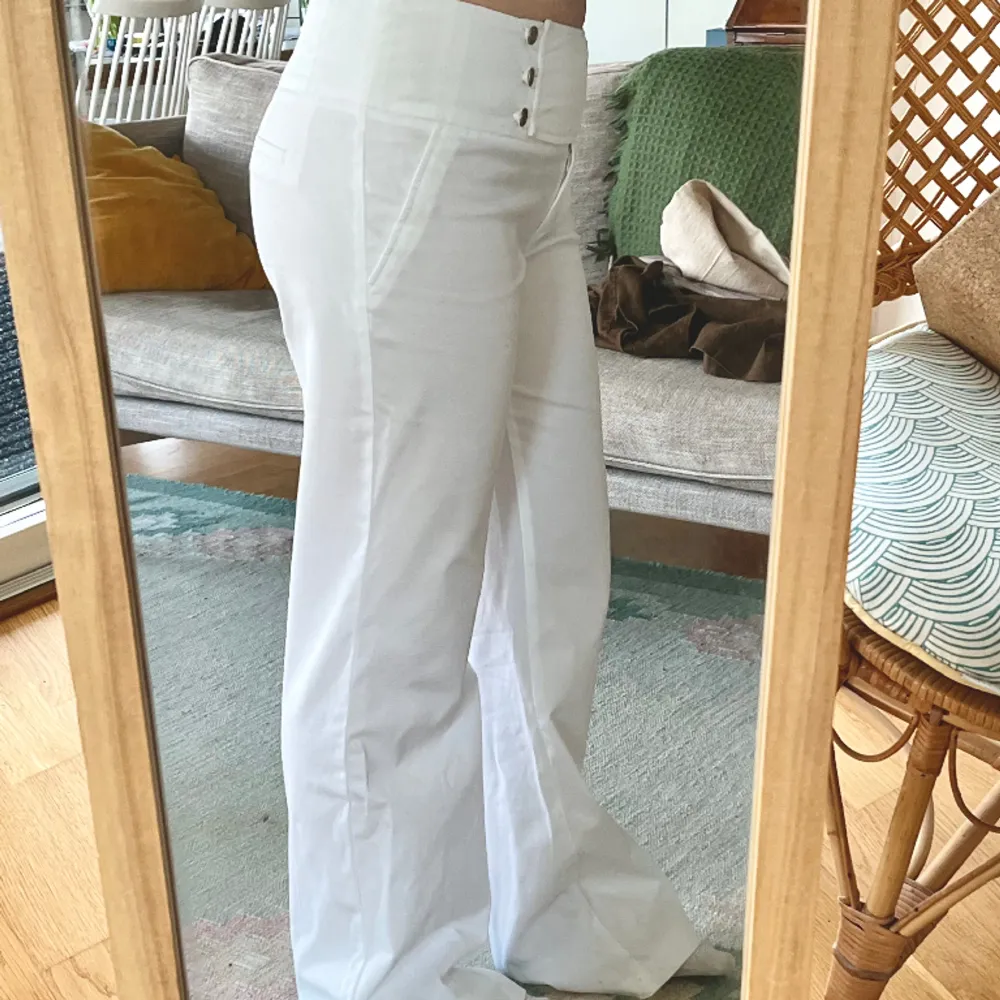 Låg/midwaist vita byxor med snygg knäppning där fram! För långa för mig som är 165 (andra bilden) midja: 41 cm innerbenslängd: 81cm Ytterbenslängd: 105 cm. Jeans & Byxor.