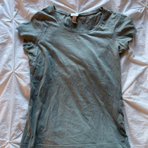 T-shirt  - Vanlig T-shirt i färgen lite mer åt det militär gröna. Använder inte så säljer den. Köpt från H&M i strl S. Använd gärna köp nu