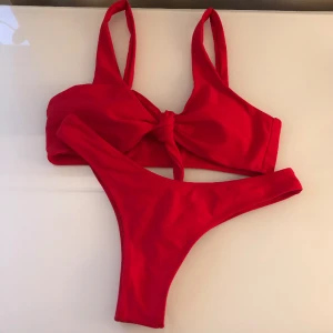 Bikini Zaful - Röd bikini från Zaful i storlek 36, använd men i mycket bra skick.  Överdel som man knyter framtill, inlägg i bysten som går att ta ut.  Bikinitrosa med scrunch baktill.  Kommer givetvis nytvättad.  Återkom vid frågor🌸☺️