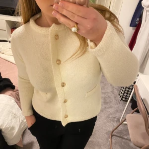 Benvit kofta med guldknappar - Supersöt kofta från Rihoas. Använd en gång, går ej att få tag på längre. 