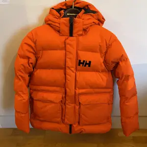 Säljer en supersnygg orange vinterjacka från Helly Hansen som tyvärr är för liten för mig. Den är knappt använd och är därför i mycket fint skick. 