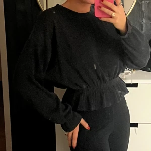 Tröja med detaljer - Mörkgrå mellantjock tröja med stretch i midjan och vid ärmarna 