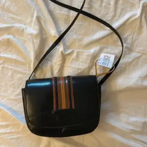 Söt svart väska med lite olika färger på framsidan! Fint skick