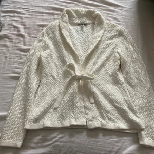 Vit kofta - Säljer denna vita koftan med knyt detalj. Bra skick och bara använd fåtal gånger. säljes då den inte används.💕