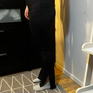 Svarta ribbade byxor slits - Svarta ribbade byxor med slits nertill. Jättesnygga och sköna. Från Gina, knappt använda och bra skick. Storlek L men passar mig som är en S 