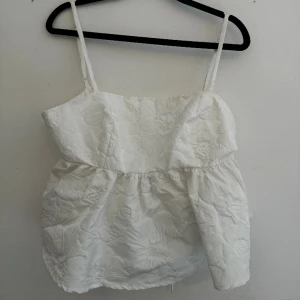 Peplumtopp från Gina - Vit peplum topp med knyte i ryggen