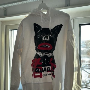 Dsquared2 Hoodie  - Likadan hoodie som 1cuz har i musikvideon ”Försent” fast  i den mer utstickande färgen vit, med andra ord ikonisk tröja. Den hade mått bra av en vit-tvätt för att få bort några fläckar. Ett litet slitage på armen så condition 5/10. Mycket prisvärd.
